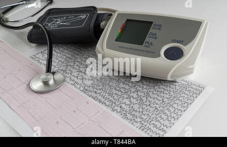 Moderno tonometro elettrico e uno stetoscopio su un grafico cardiogram. famiglia monitor della pressione del sangue Foto Stock