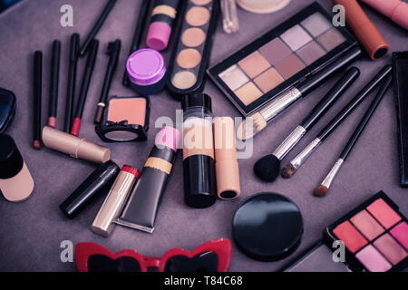 Close up di cosmetici varietà giacente sul tavolo in camera Foto Stock