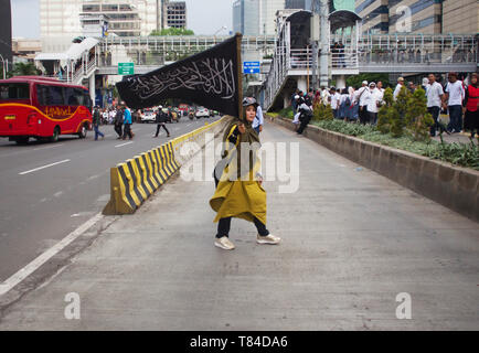 Jakarta, Indonesia. Il 10 maggio, 2019. Una donna si vede tenendo un flag durante la dimostrazione.i sostenitori del candidato presidenziale Prabowo Subianto dimostrato circa i risultati delle elezioni che sono state considerate fraudolente davanti al palazzo della elezione dell organismo di vigilanza o Bawaslu. Credito: Nick Hanoatubun SOPA/images/ZUMA filo/Alamy Live News Foto Stock