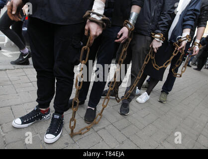 Kiev Kiev, Ucraina. Il 10 maggio, 2019. Gli attivisti si vede con catene durante l atto.attivisti ucraini di ''Save Oleg Sentsov'' iniziativa globale ha segnato il quinto anniversario della detenzione del regista ucraino Oleg Sentsov mediante una dimostrazione, Oleg serve una pena di vent'anni in Russia per il terrorismo. Gli attivisti hanno chiamato i paesi dell'UE per aumentare la pressione sulla Russia che mira a liberare Oleg Settsov e altri 70 ucraino prigionieri politici incarcerati in Russia. Credito: Pavlo Gonchar SOPA/images/ZUMA filo/Alamy Live News Foto Stock