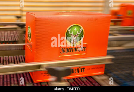 10 maggio 2019, Bassa Sassonia, Wolfenbüttel: Nella recentemente ampliato impianto di riempimento del produttore di bevande Jägermeister, una scatola di cartone con Jägermeister bottiglie viene trasportato su un nastro trasportatore. Con questa espansione, Jägermeister ha, secondo le proprie informazioni, realizzato uno dei più grandi spiriti di impianti di imbottigliamento in Europa. Foto: Christophe Gateau/dpa Foto Stock