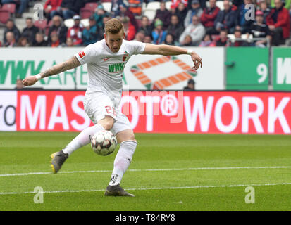Augsburg, Germania. 11 Maggio, 2019. Calcio: Bundesliga, FC Augsburg - Hertha BSC, XXXIII giornata in WWK-Arena. Andre Hahn da Augsburg Spara la palla. Credito: Stefan Puchner/dpa - NOTA IMPORTANTE: In conformità con i requisiti del DFL Deutsche Fußball Liga o la DFB Deutscher Fußball-Bund, è vietato utilizzare o hanno utilizzato fotografie scattate allo stadio e/o la partita in forma di sequenza di immagini e/o video-come sequenze di foto./dpa/Alamy Live News Foto Stock