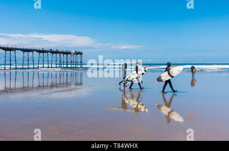 Saltburn dal mare, North Yorkshire, Regno Unito. 11 maggio 2019. Meteo: un surfers voce fuori a Saltburn sulla North Yorkshire coast nel glorioso sole come la città celebra il centocinquantesimo anniversario ot il suo molo vittoriano. Credito: Alan Dawson/Alamy Live News Foto Stock