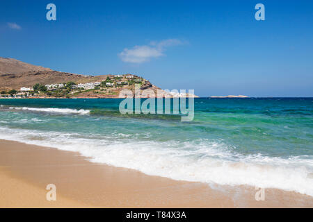Panormos, Mykonos, Egeo Meridionale, Grecia. Vista dalla spiaggia sabbiosa attraverso le acque turchesi di Panormos Bay. Foto Stock