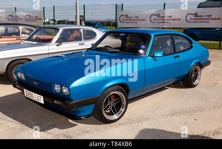 Tre quarti frontale di un blu, 1984 Ford Capri, nel paddock intenzionale, al 2019 Silverstone Classic Media Day Foto Stock