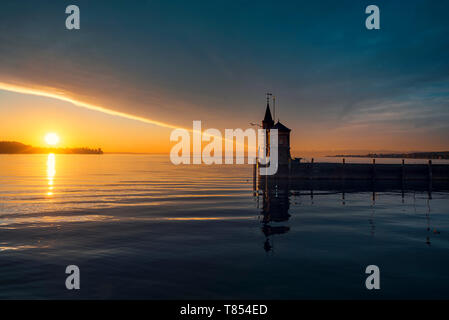 Inizio estate mattina sul lago Bodensee, Konstanz, Germania. Sunrise su acqua e del faro. Cloudscape e sun riflette sull'acqua. Foto Stock