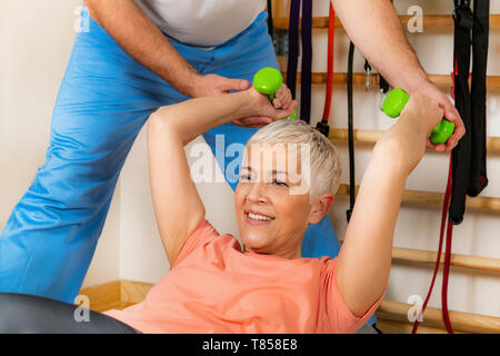 Senior donna esercita sulla sfera di pilates Foto Stock