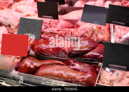 Espositore refrigerato con carni fresche in macelleria Foto Stock