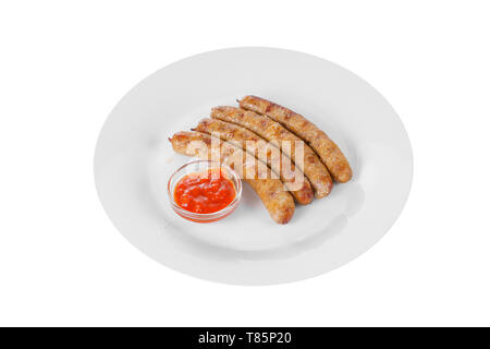 Quattro salsicce alla griglia senza guarnire con pomodoro piccante salsa rossa, ketchup su una piastra, isolato su sfondo bianco, vista laterale Foto Stock
