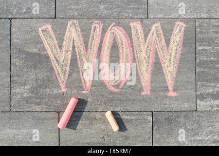 Wow scritto sul marciapiede grigio, vista dall'alto. Foto Stock