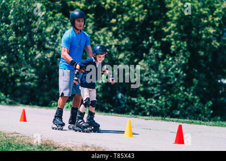 Nonno nipote di insegnamento per pattino a rotelle Foto Stock