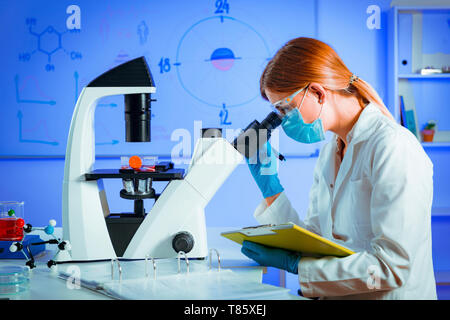 Scienziato usando microscopio Foto Stock