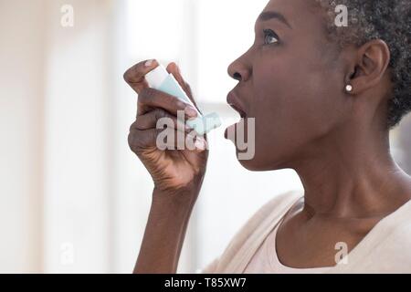 Donna che utilizza inalatore Foto Stock