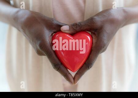 Donna che mantiene la forma di cuore Foto Stock