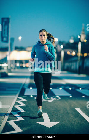 Donna jogging nella città di notte Foto Stock