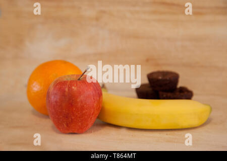 Scelta tra apple, banana e arancio o qualche piccolo morso dimensioni brownies Foto Stock