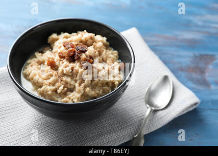 Gustosa farina di avena con uvetta nella ciotola sul tavolo Foto Stock