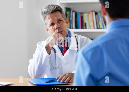 Coppia medico ascolto paziente presso ufficio di ospedale Foto Stock