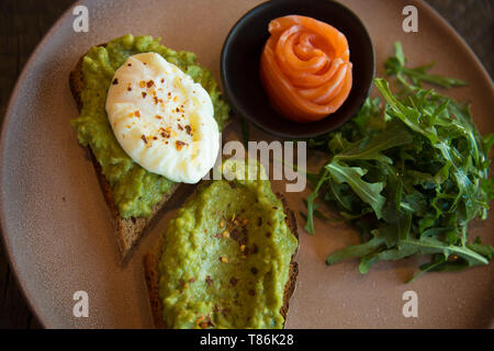 Antipasti Gourmet salmone avocado diffusione toast piastra di rucola vista superiore Foto Stock