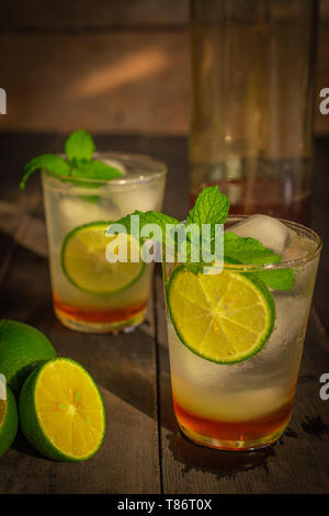 Ghiaccio fresco miele limone soda drink sulla tavola di legno ci sono fetta di limone, lo stesso oggetto e il miele in una bottiglia di vetro posto attorno a. Foto Stock