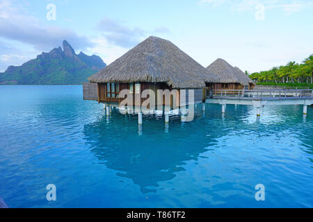 BORA BORA, Polinesia francese -3 DEC 2018- Vista di bungalow Overwater ville con tetto in paglia in laguna Bora Bora in Polinesia francese. Foto Stock