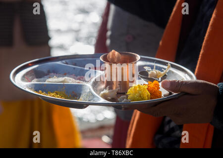 Chiusura del sacerdote Indù mano azienda pooja thali in mano Foto Stock