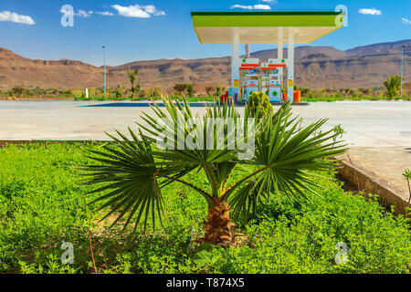 Green Gas Station in zone aride, nel deserto, contro lo sfondo delle montagne Atlas in Marocco. Foto Stock