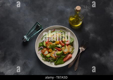 Medio Oriente grigliate di formaggio halloumi con insalata di avocado, arance, pomodori ciliegini, cipolla rossa, rucola foglie di bietola. Foto Stock