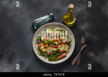 Medio Oriente grigliate di formaggio halloumi con insalata di avocado, arance, pomodori ciliegini, cipolla rossa, rucola foglie di bietola. Foto Stock