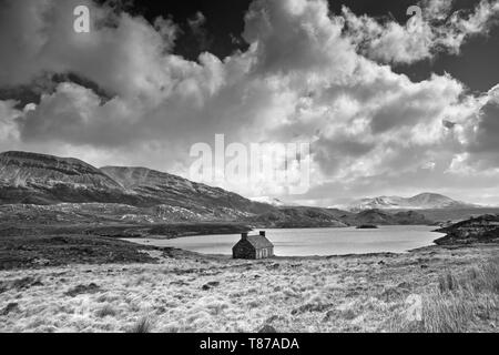 Vecchia capanna da Loch Stack, Arkle in salita sulla sinistra, Sutherland, Highlands scozzesi, UK, blustery ventoso aprile meteo, nuvole temporalesche, drammatico paesaggio. Foto Stock