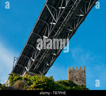 Medievale torre di vedetta a Muralha Fernandina Castello con Dom Luiz I Bridge a Porto, Portogallo, Europa. Foto Stock