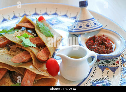 Olio di oliva e marocchine Harissa salsa chili servita con Cuscus salato Crepes Foto Stock