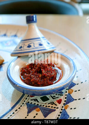 Harissa marocchino pasta di peperoncino in un Mini pentola Tajine servita con piatto marocchino Foto Stock