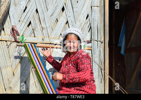 Basar, Arunachal Pradesh, India - 10 gennaio 2019: Ritratto Galo tribù donna preparazione di telai per tessitura la sciarpa a colori, nella tradizione di sfondo Foto Stock