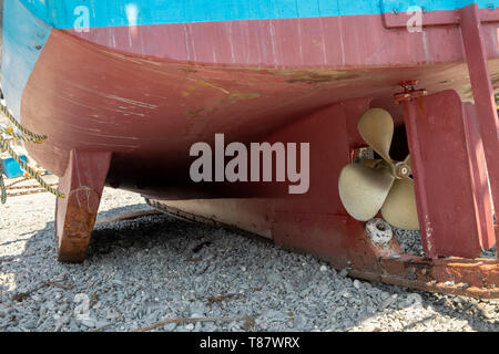 Retro di una tradizionale barca da pesca che mostra l'elica e timone, sulla spiaggia nel piccolo villaggio di pescatori di Cadgwith,cornwall, England, Regno Unito Foto Stock
