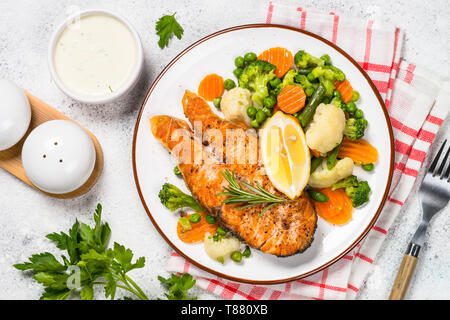 Salmone alla griglia bistecca di pesce con verdure su bianco. Foto Stock