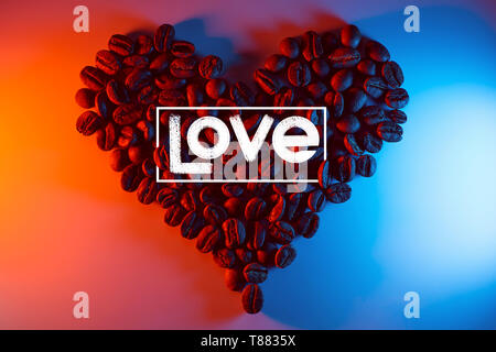 I chicchi di caffè sono evidenziate con neon colorati rivestiti in forma di cuore Foto Stock