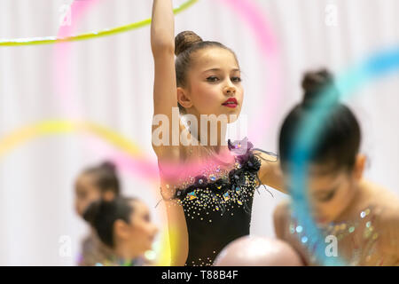 Ritratto di una piccola e graziosa fanciulla cercando di vincere la ginnastica ritmica campionato, ballando con un cerchio e indossa bellissimi Body ricamato wit Foto Stock