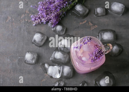 Mason jar con limonata di lavanda e cubetti di ghiaccio su sfondo grigio Foto Stock