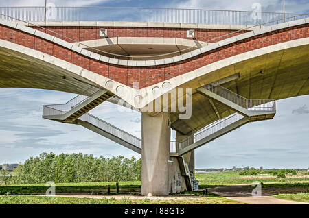 Nijmegen, Paesi Bassi, 25 Aprile 2019: scala a doppia rampa che conduce attraverso il calcestruzzo e mattoni archi del Ponte De OVersteek verso il sentiero Foto Stock