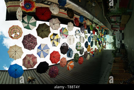 Display a colori di ombrelli appeso sopra una stradina in Hardbrücke, un artista-infestato la località di Zurigo Foto Stock