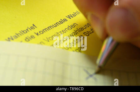 Stuttgart, Germania. Il 10 maggio, 2019. Illustrazione - un uomo segna un voto cartaceo del bollettino postale scrutinio per l'elezione locale nel Baden-Württemberg. Credito: Sebastian Gollnow/dpa/Alamy Live News Foto Stock