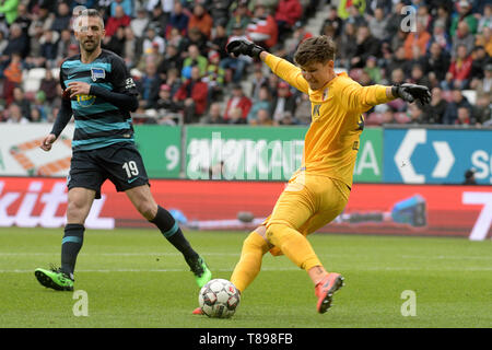 Augsburg, Germania. 11 Maggio, 2019. Calcio: Bundesliga, FC Augsburg - Hertha BSC, XXXIII giornata in WWK-Arena. Il portiere Gregor Kobel (r) da Augsburg chiarisce davanti a Vedad Ibisevic da Berlino. Credito: Stefan Puchner/dpa - Utilizzare solo dopo accordo contrattuale/dpa/Alamy Live News Foto Stock