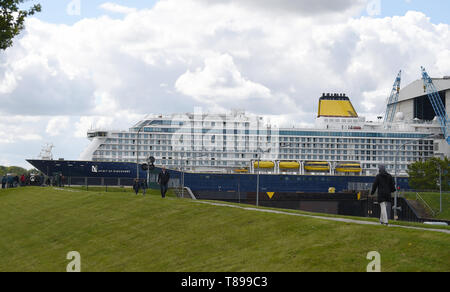 Papenburg (Germania). Il 12 maggio 2019. I visitatori osservano la nave da crociera "spirito di scoperta' lasciando il cantiere navale Meyer Werft la costruzione di dock su una diga. "Lo spirito di scoperta' è 236 metri di lunghezza e poco più di 31 metri di larghezza. Credito: Carmen Jaspersen/dpa/Alamy Live News Foto Stock