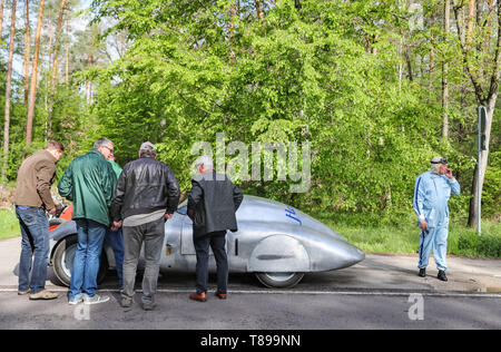 Dessau-Roßlau, Germania. Il 12 maggio 2019. Il conducente di un'altra auto d'epoca, utilizza una pausa forzata per una sigaretta accanto a un'efficiente Hanomag diesel per riparare la vettura. Dodici anni sono stati necessari per gli appassionati di tecnologia dalla regione di Hannover per ricostruire il leggendario Hanomag diesel da 1938. Nel 1939 il set originale di quattro record mondiali sulla A9 tra Bitterfeld e Dessau. Tuttavia, una nuova edizione con la replica non è riuscita a causa di problemi al motore. Foto: Jan Woitas/dpa-Zentralbild dpa/credito: dpa picture alliance/Alamy Live News Foto Stock