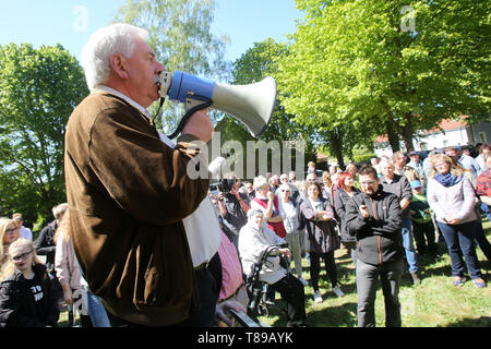 Larz, Germania. Il 12 maggio 2019. Hartmut Lehmann, sindaco del comune di Lärz, parla in un rally per la conservazione della cultura e della musica festival 'Fusion'. Circa un centinaio di persone hanno protestato domenica in Lärz (Meclemburgo Lake District) contro una stazione di polizia e pattuglie di polizia presso l'alternativa 'Fusion' festival. Credito: dpa picture alliance/Alamy Live News Foto Stock