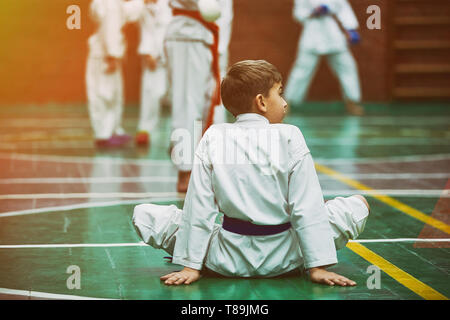 Giovane ragazzo di karate il riscaldamento in un kimono Foto Stock