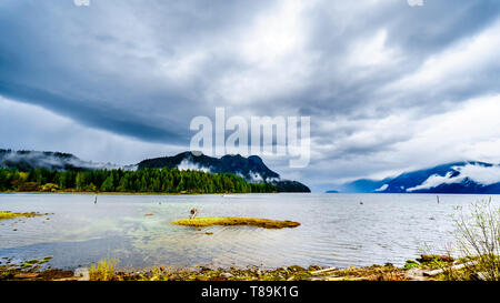 Cielo nuvoloso scuro su Pitt lago ed appendere intorno le montagne della costa Mountain Range in Fraser Valley della British Columbia, Canada Foto Stock