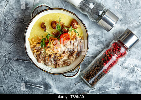 Carni bovine stroganoff con purè di patate in una pentola. vista dall'alto, sullo sfondo di pietra Foto Stock