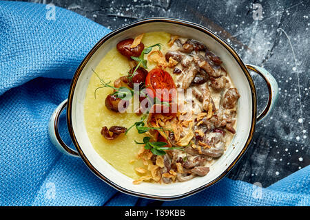 Carni bovine stroganoff con purè di patate in una pentola. vista dall'alto, sullo sfondo di pietra Foto Stock